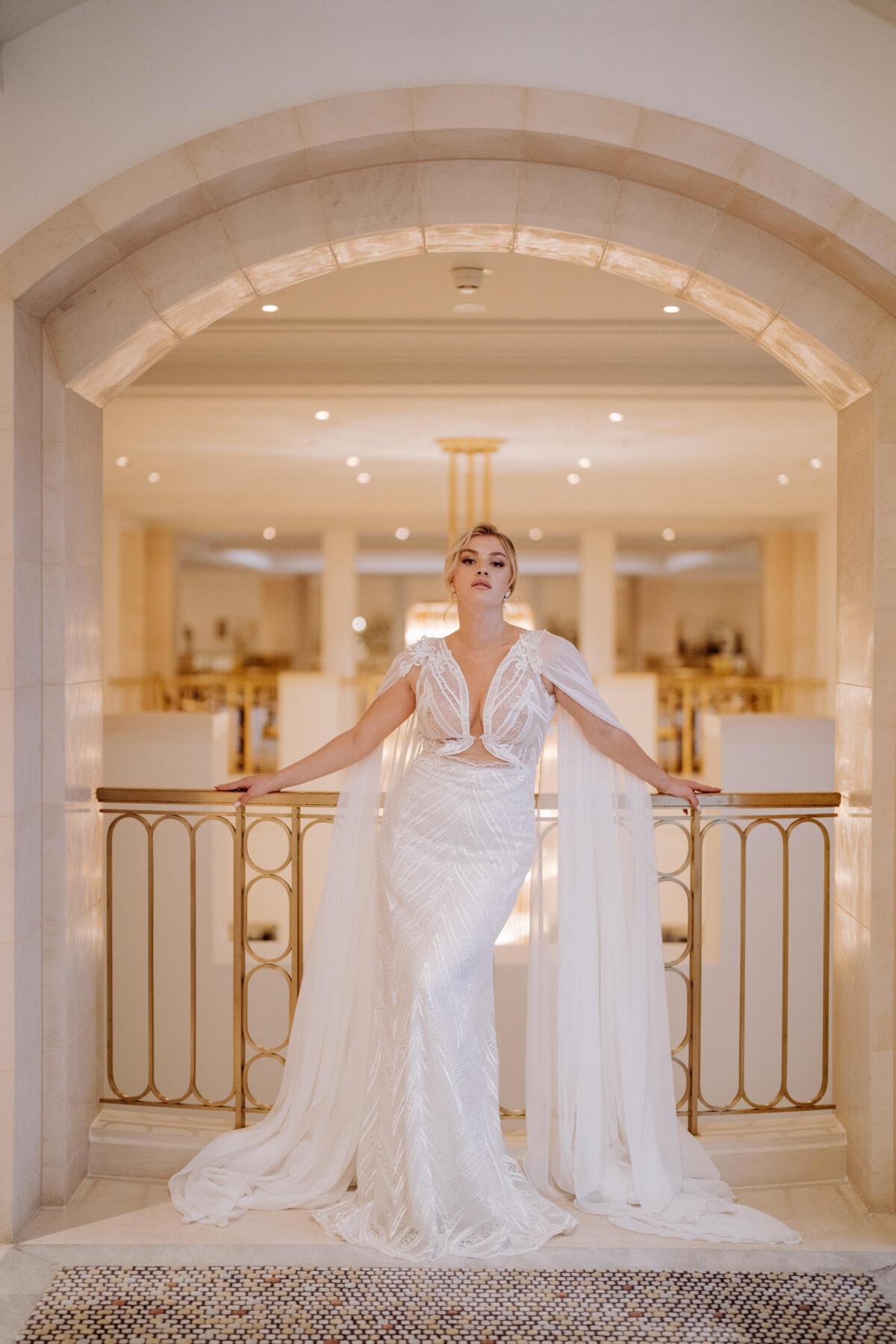 Glamouröses Brautkleid mit Flügeln GRACE von MALLOE im figurbetonten Fit-and-Flare-Stil, mit funkelnder Art-Deco-Spitze, tiefem V-Ausschnitt, offenem Rücken und bodenlangen Chiffon-Flügeln