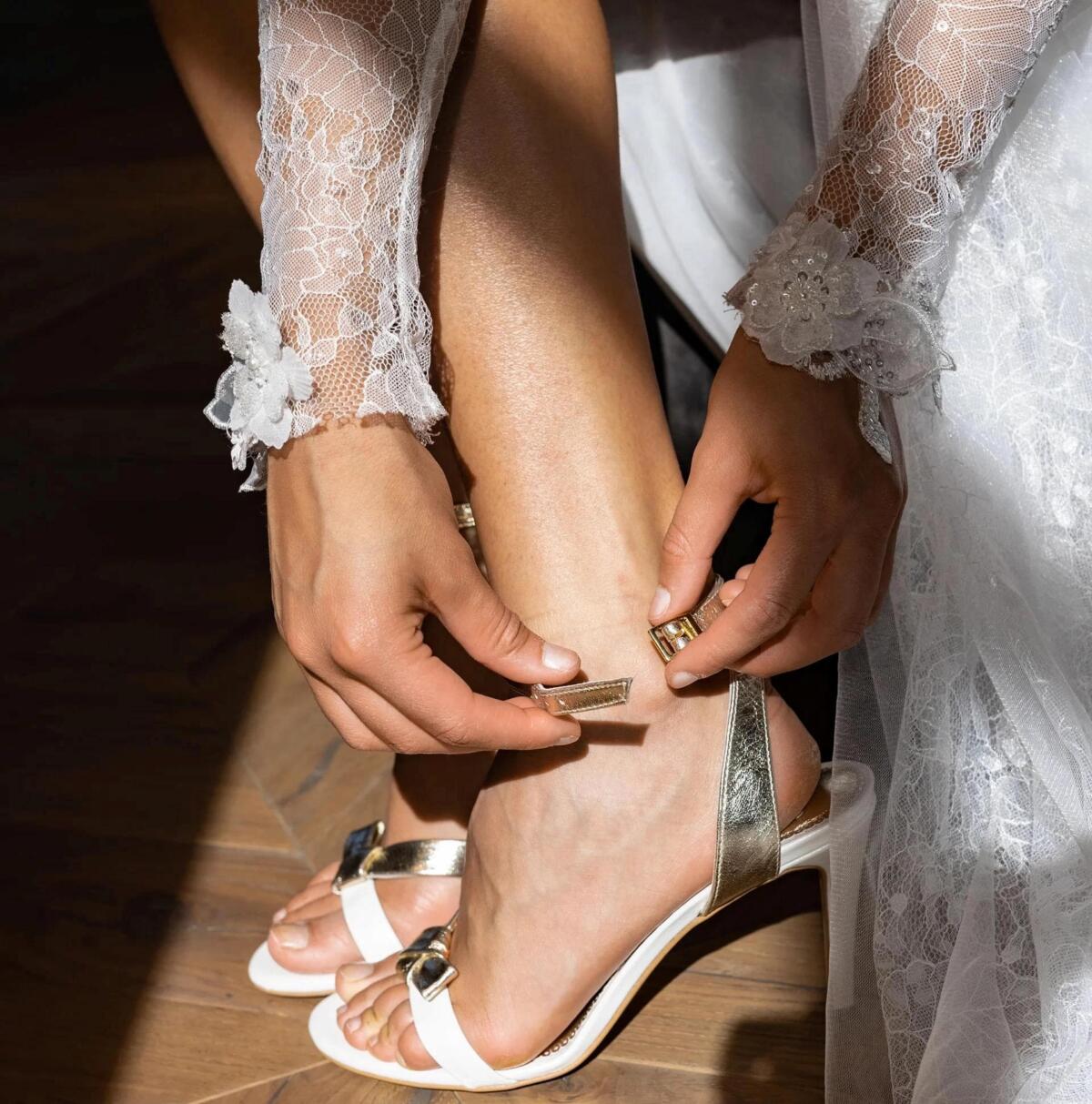 Braut hält einen eleganten Brautschuh von MALLOE in der Hand